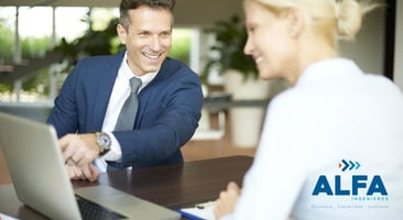 Mujer y hombre sonriendo mientras mantienen una reunión en la oficina